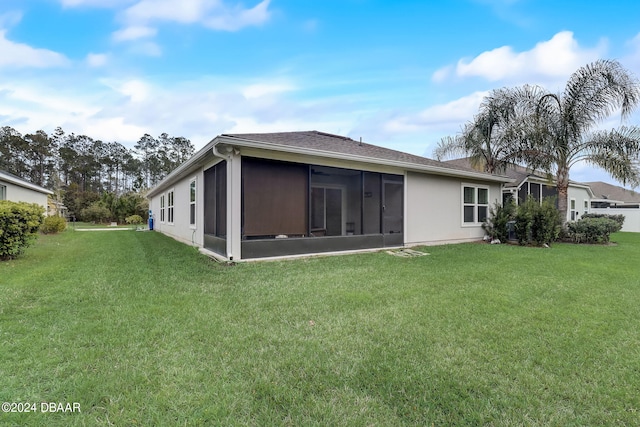 rear view of property featuring a sunroom and a yard