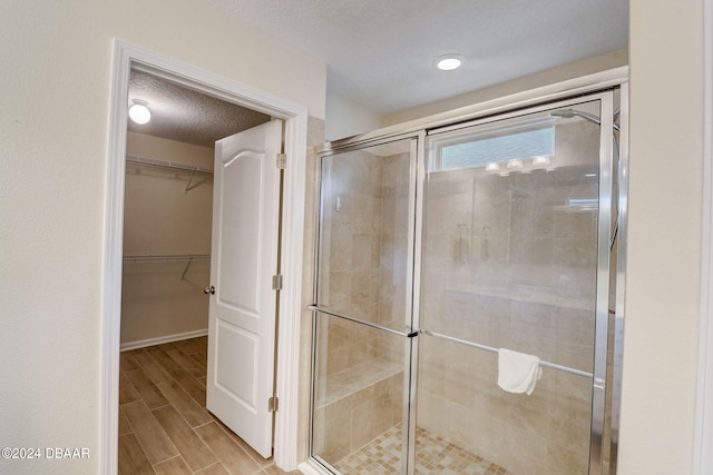 bathroom with an enclosed shower and a textured ceiling