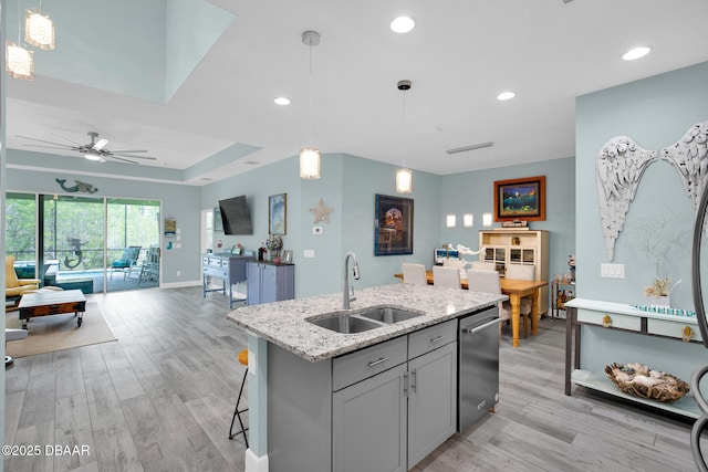 308 Low Tide Ln, Daytona Beach, FL 32124 - kitchen featuring stainless steel dishwasher, open floor plan, light wood-style floors, light stone countertops, and a ceiling fan