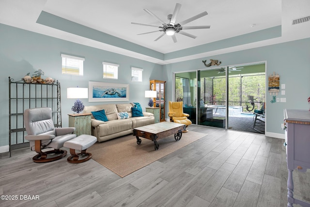 308 Low Tide Ln, Daytona Beach, FL 32124 - living area featuring a tray ceiling, wood finished floors, and ceiling fan