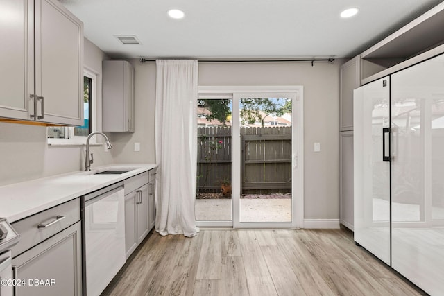 kitchen featuring gray cabinets, light hardwood / wood-style floors, sink, and dishwasher