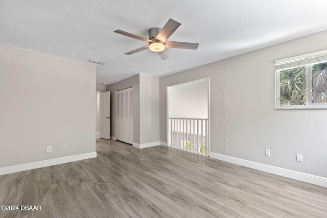 spare room with ceiling fan, a textured ceiling, and light hardwood / wood-style flooring