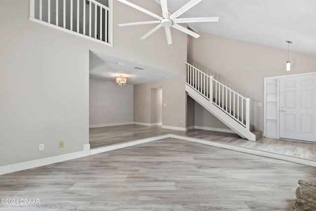 unfurnished living room with high vaulted ceiling and light hardwood / wood-style flooring