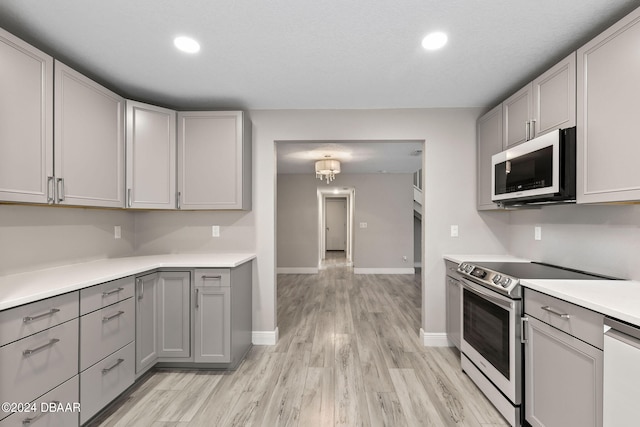 kitchen featuring appliances with stainless steel finishes, gray cabinetry, and light hardwood / wood-style flooring