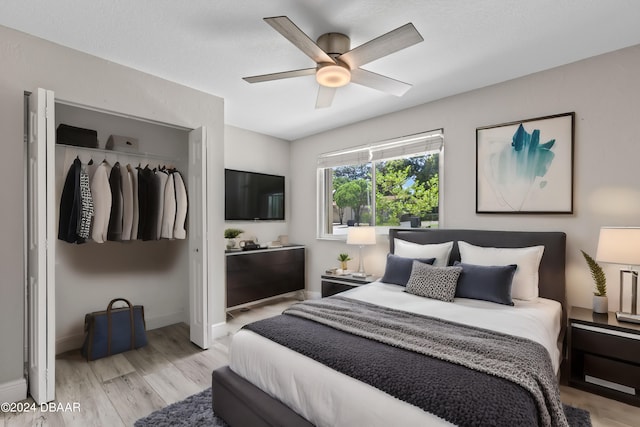 bedroom with light hardwood / wood-style floors, ceiling fan, and a closet