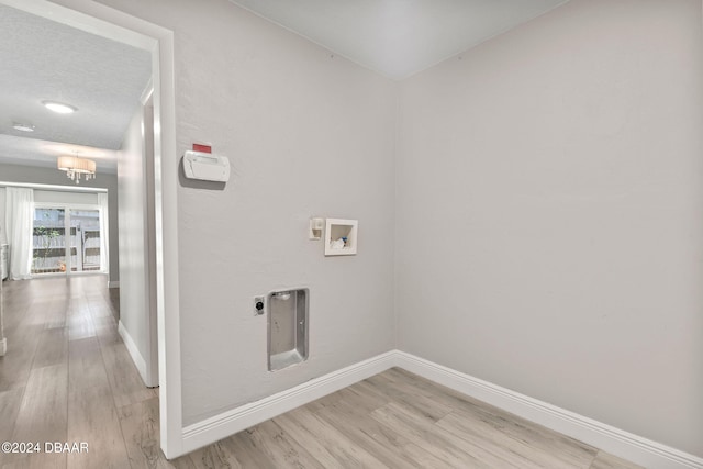 clothes washing area featuring light hardwood / wood-style floors, electric dryer hookup, an inviting chandelier, a textured ceiling, and hookup for a washing machine