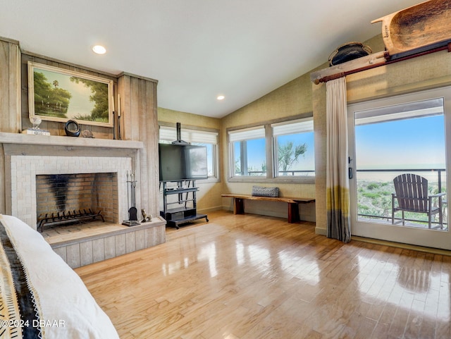 living room featuring a fireplace, hardwood / wood-style flooring, and vaulted ceiling