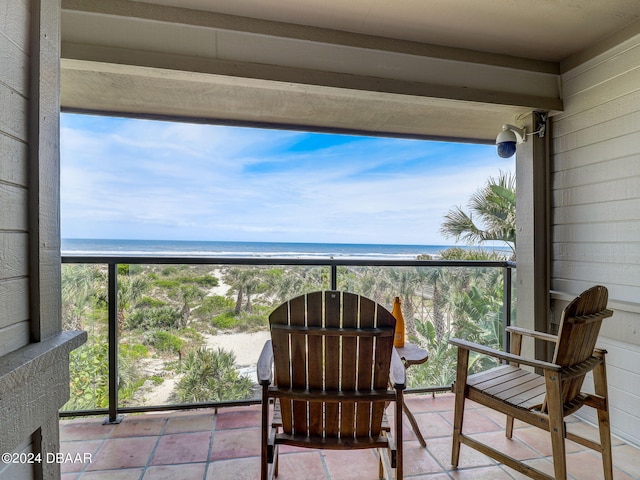 balcony featuring a view of the beach and a water view