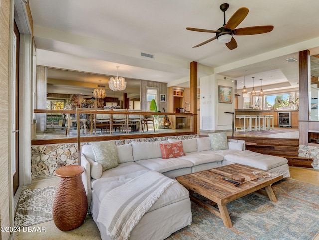 living room featuring ceiling fan with notable chandelier