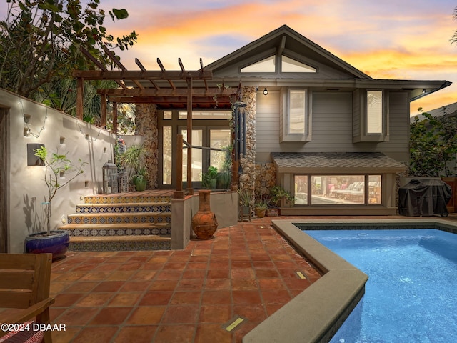 back house at dusk with a patio area and a pergola