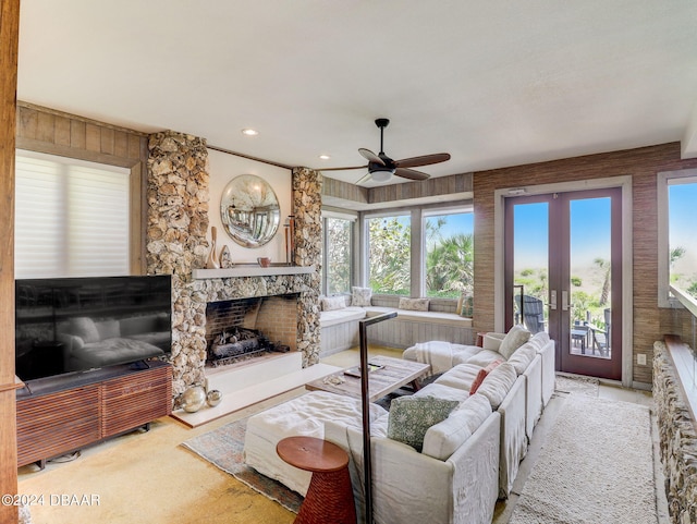 living room with a fireplace, plenty of natural light, and ceiling fan