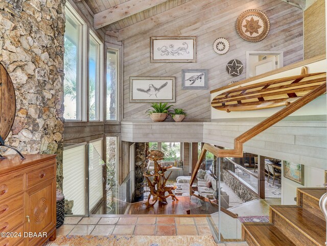 interior space featuring wooden walls, hardwood / wood-style floors, wooden ceiling, and plenty of natural light