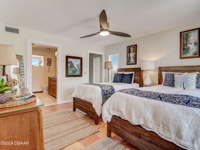 bedroom featuring light tile patterned flooring, ceiling fan, and ensuite bathroom