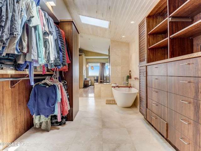 walk in closet featuring vaulted ceiling with skylight