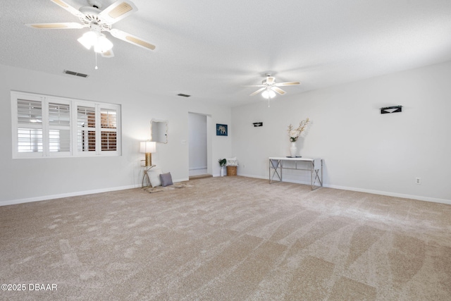 unfurnished living room with a textured ceiling, light colored carpet, and ceiling fan