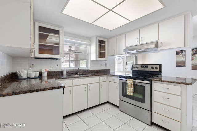 kitchen with white cabinets, electric stove, sink, light tile patterned flooring, and kitchen peninsula