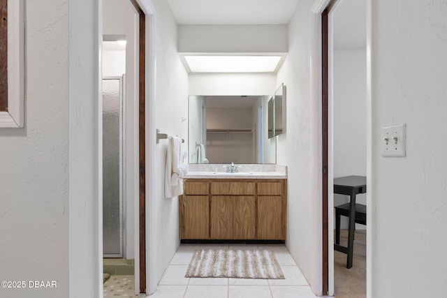 bathroom featuring tile patterned flooring, vanity, and walk in shower