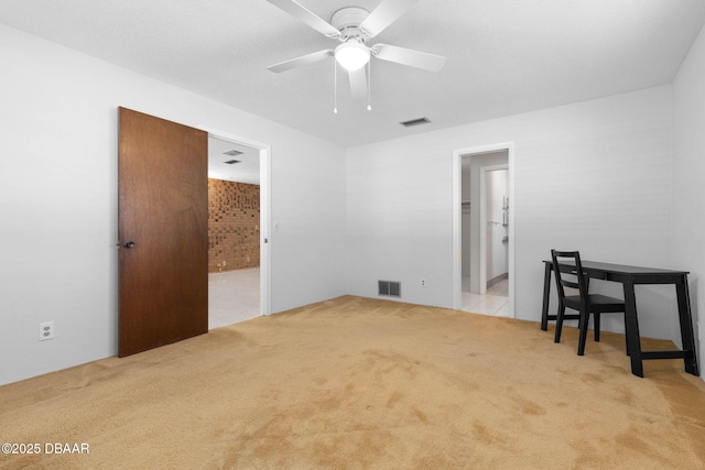 spare room featuring light colored carpet and ceiling fan