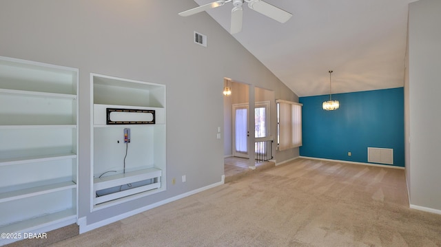 unfurnished living room with built in features, high vaulted ceiling, ceiling fan with notable chandelier, and light carpet