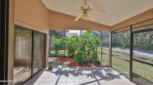 unfurnished sunroom with vaulted ceiling, ceiling fan, and plenty of natural light