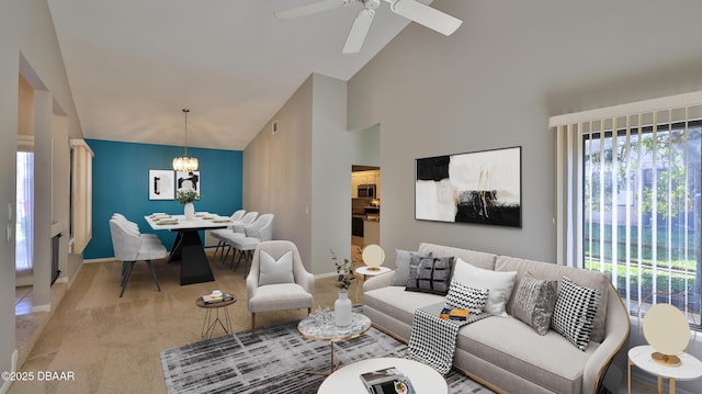 living area featuring baseboards, carpet, high vaulted ceiling, and ceiling fan with notable chandelier
