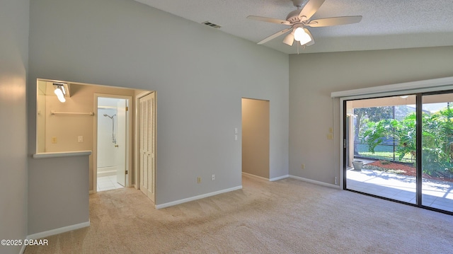 empty room featuring ceiling fan, high vaulted ceiling, light carpet, and a textured ceiling