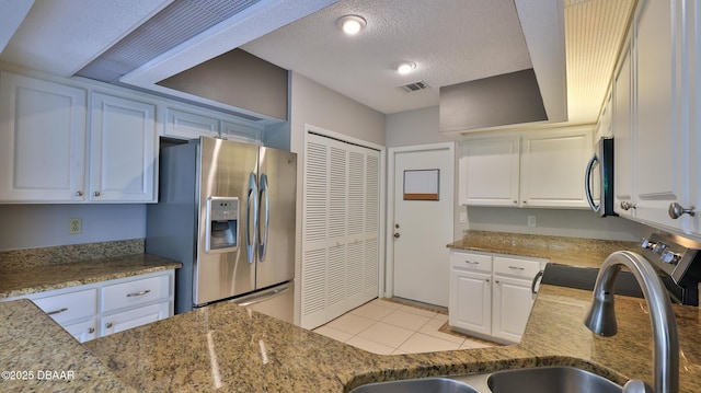 kitchen featuring light tile patterned flooring, sink, white cabinetry, a textured ceiling, and appliances with stainless steel finishes