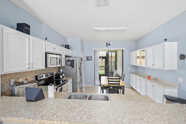 kitchen featuring white cabinets, sink, a textured ceiling, tasteful backsplash, and stainless steel appliances