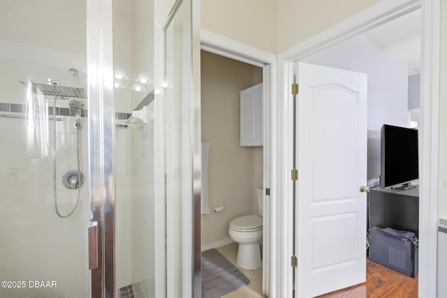 bathroom featuring wood-type flooring, toilet, and a shower with door