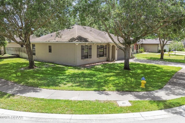 ranch-style home with a garage and a front lawn