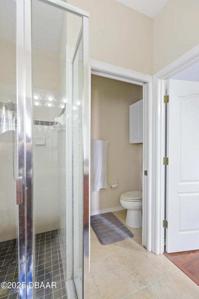 bathroom with toilet and a shower with door