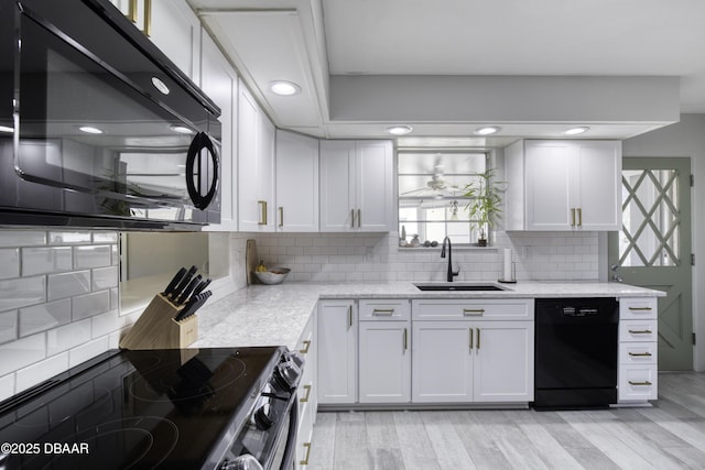 kitchen featuring black appliances, white cabinets, tasteful backsplash, and a sink