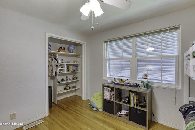 interior space with visible vents, baseboards, ceiling fan, and wood finished floors