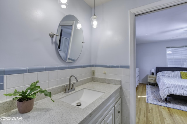 bathroom featuring tile walls, wood finished floors, and vanity