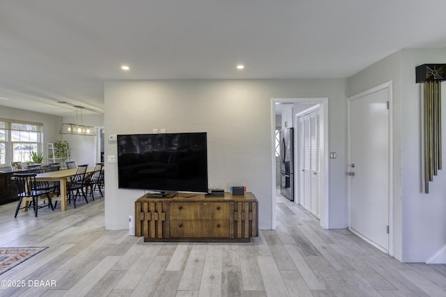 living area with light wood finished floors, recessed lighting, and baseboards