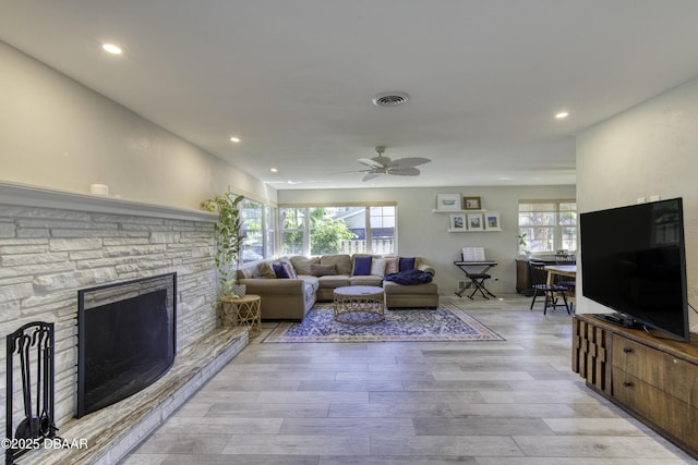 living area featuring visible vents, recessed lighting, light wood-style flooring, a fireplace, and a ceiling fan