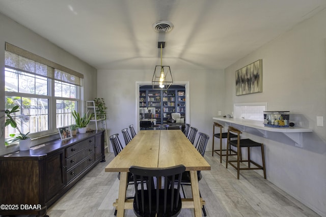 dining area featuring visible vents and light wood-style flooring