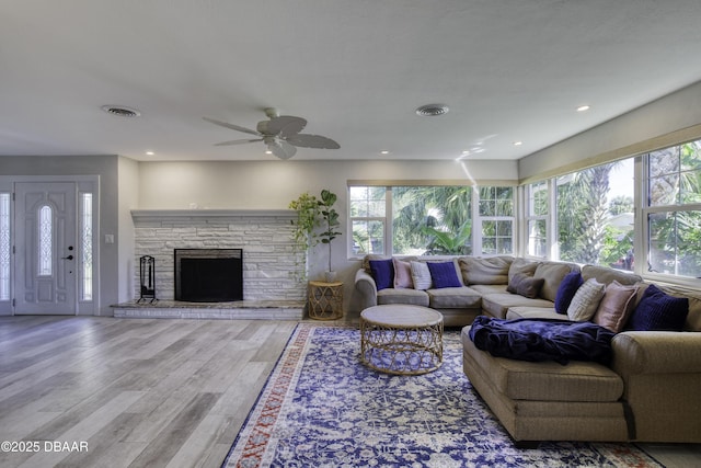 living room featuring wood finished floors, visible vents, a wealth of natural light, and ceiling fan