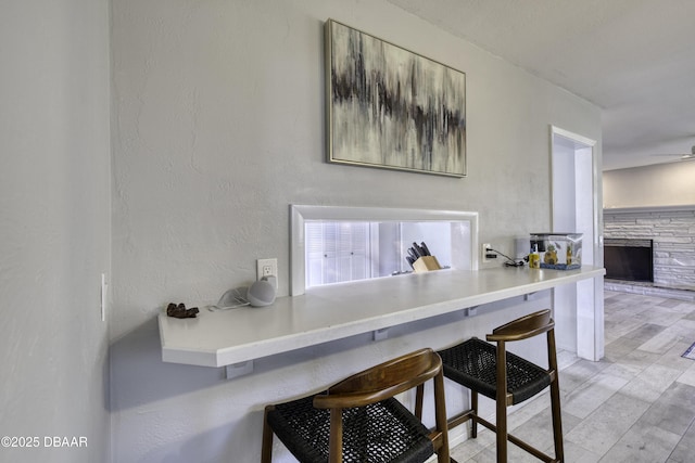 office featuring ceiling fan, a fireplace, and a textured wall