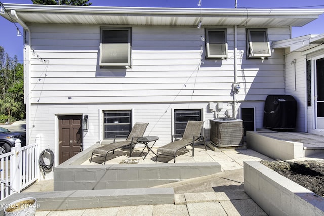 rear view of property with central air condition unit and a patio area