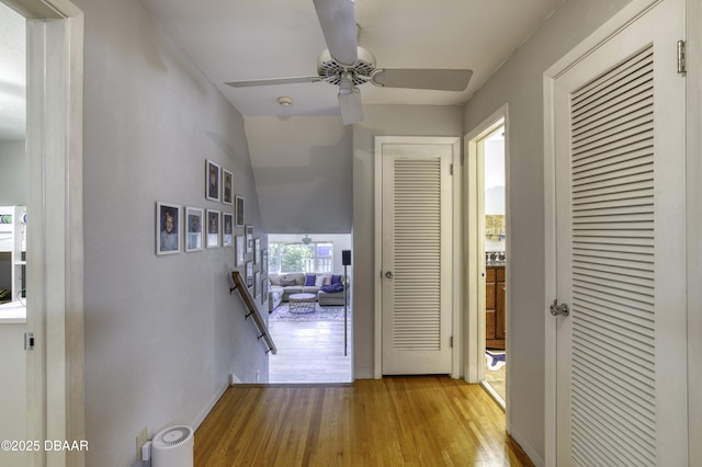 hall featuring an upstairs landing and light wood-style floors