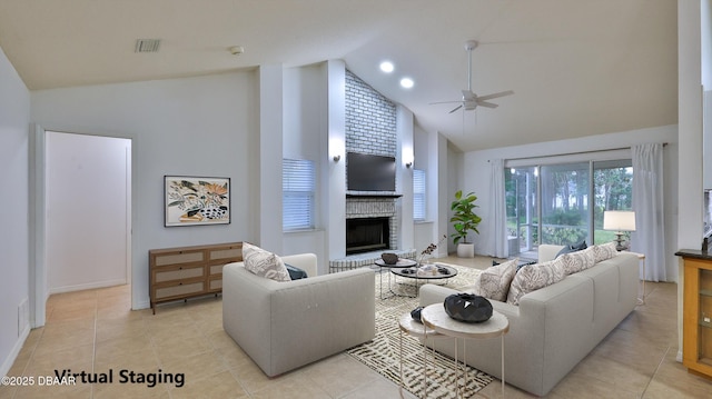 living room featuring a fireplace, high vaulted ceiling, light tile patterned flooring, and ceiling fan