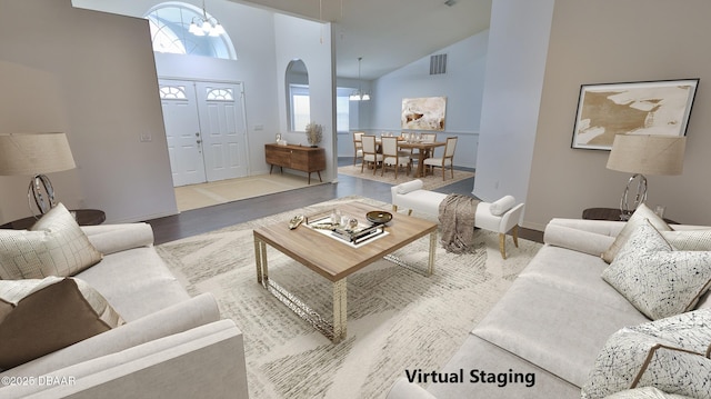 living room featuring high vaulted ceiling, a chandelier, and light hardwood / wood-style flooring