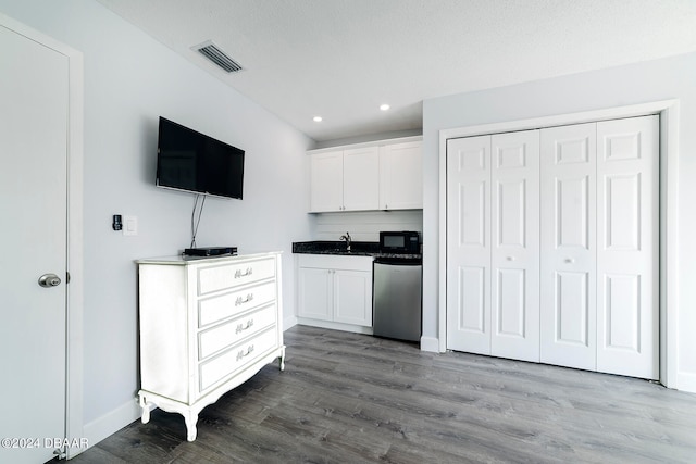 kitchen with dark hardwood / wood-style flooring, white cabinets, dishwasher, a textured ceiling, and sink