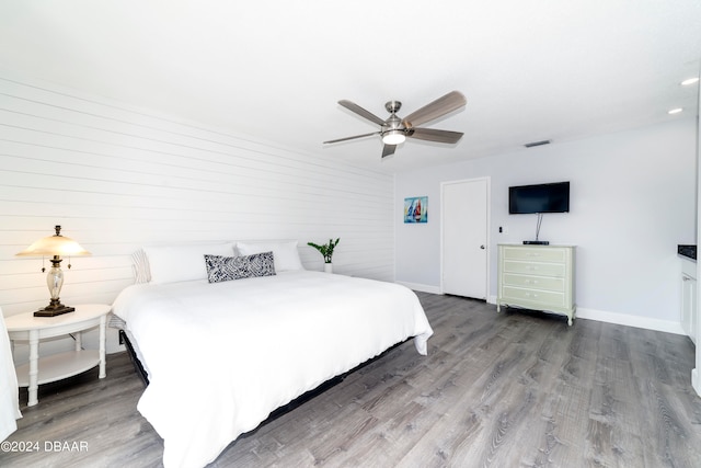 bedroom with dark hardwood / wood-style flooring and ceiling fan