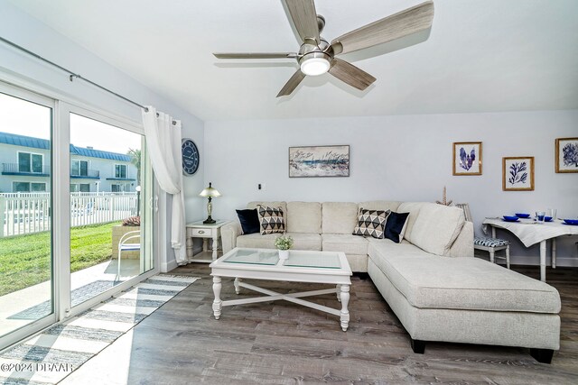 living room featuring dark wood-type flooring, a healthy amount of sunlight, and ceiling fan