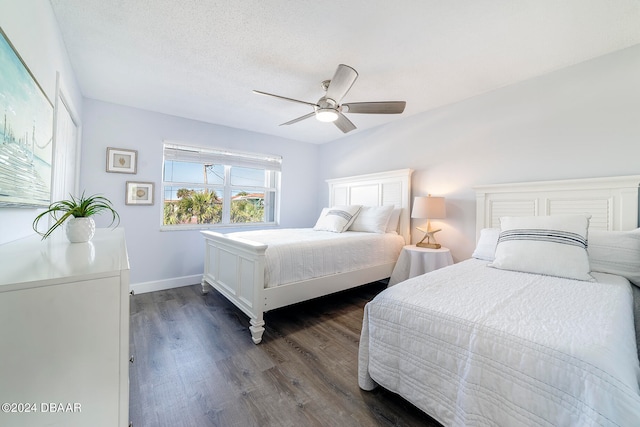 bedroom featuring dark hardwood / wood-style flooring, a textured ceiling, and ceiling fan