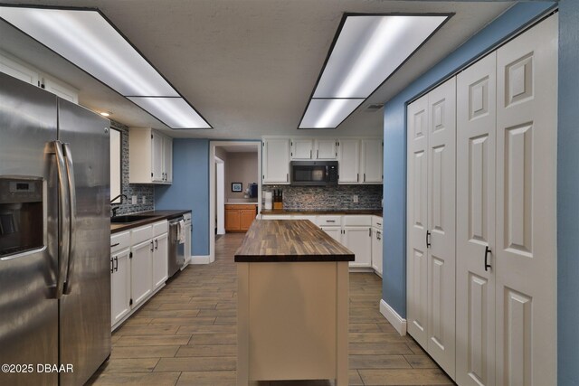 180 Willow Run, Ormond Beach, FL 32174 - kitchen with wood counters, appliances with stainless steel finishes, dark wood-type flooring, and tasteful backsplash