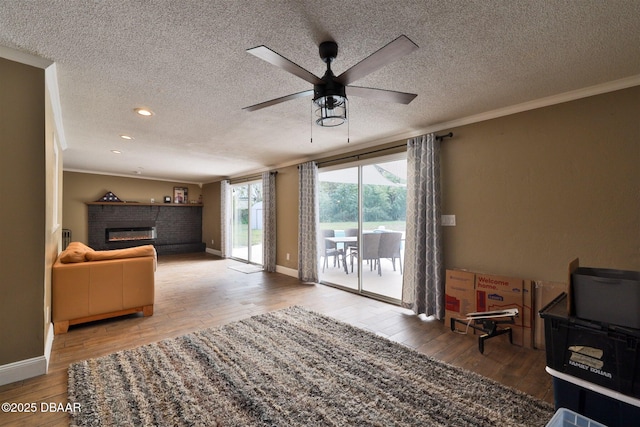 180 Willow Run, Ormond Beach, FL 32174 - living room with a textured ceiling, ceiling fan, hardwood / wood-style floors, ornamental molding, and a fireplace