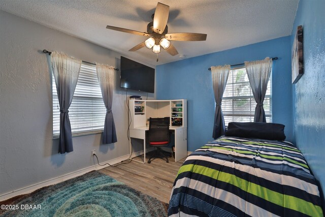 180 Willow Run, Ormond Beach, FL 32174 - bedroom featuring a textured ceiling, wood finished floors, a ceiling fan, a desk, and baseboards